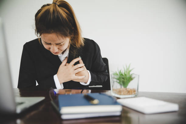 Asian businesswoman  in a black suit is sick with chest pain stock photo