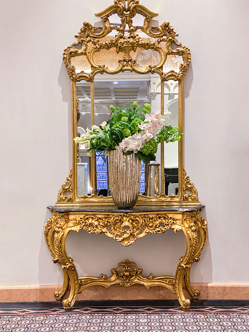 Luxury interior detail with golden mirror and console table