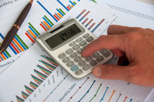 istock Hand pressing calculator with graph analysis background. Business analysis concept 1426589165