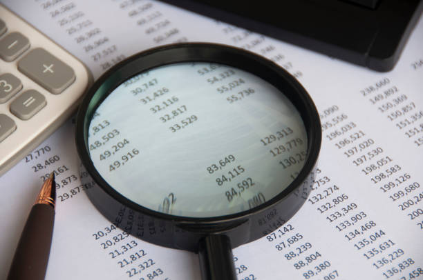 istock Business analysis concept - magnifying glass with calculator and number analysis background. Copy space 1426589170