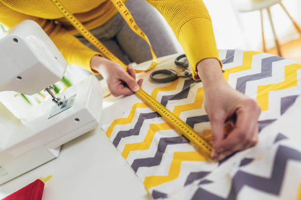 istock Woman sewing on a sewing machine at her home, close up. 1426601448
