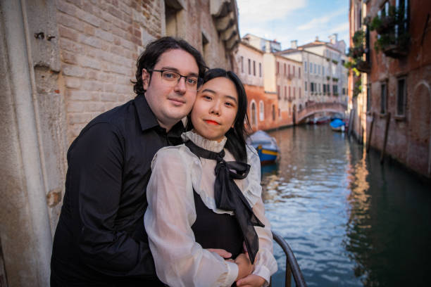 istock Young engaged couples standing by the canal hugging each other look in the same direction 1426601665
