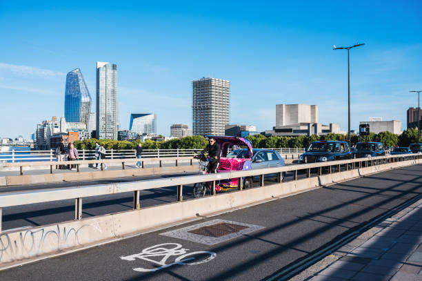 rickshaw bicycle taxi riding on waterloo bridge followed by the cars - tower london england greater london inner london imagens e fotografias de stock