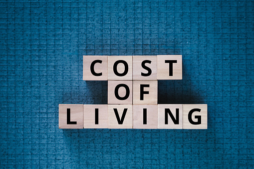 Cost of Living words on cubes placed on blue grid background