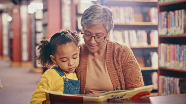 Book, grandparent and reading with child in library for family bonding time with grandchild. Education, support and grandmother teaching literature skill and knowledge in community centre.