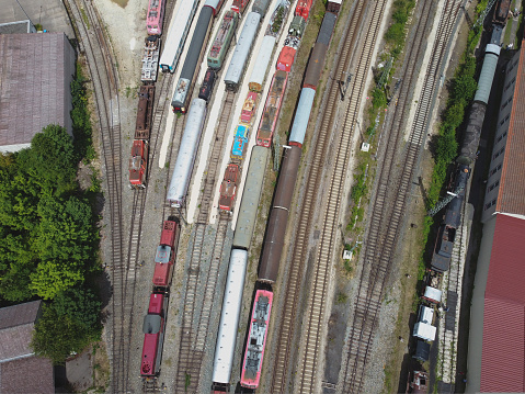 Cargo trains close-up. Aerial view of colorful freight trains on the railway station. Wagons with goods on railroad. Heavy industry. Industrial conceptual scene with trains. Top view flying drone.