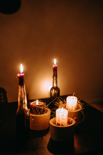 Five beautifully decorated candles stand on a table in a dark room. Romance atmosphere