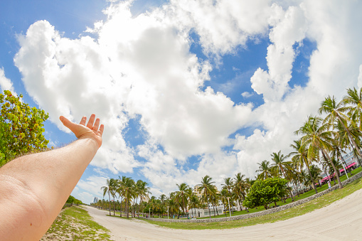 POV Point of view shot of a young male having fun in South Beach, Miami Beach, Miami, South Florida, United States of America. On back, the famous Ocean Drive Avenue.

Shooting from a personal perspective in an exotic tropical beach travel holidays.