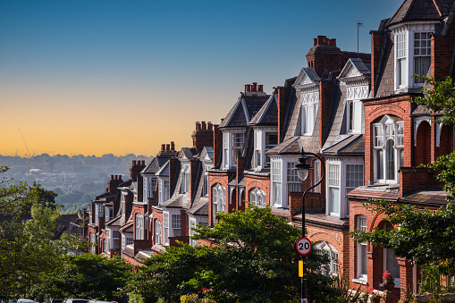 Row of traditional English terraced houses in Muswell Hill during sunset in London, England
