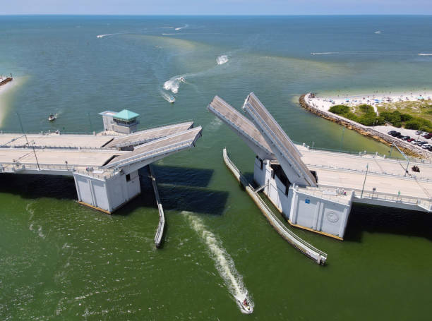 Aerial View of Johns Pass Bridge in Treasure Island, FL Aerial view of bascule drawbridge opening for boat traffic in Florida with the Gulf of Mexico in the background opening bridge stock pictures, royalty-free photos & images