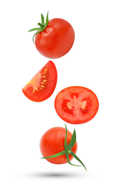 istock Whole tomato and slices falling in the air isolated on white 1426635983