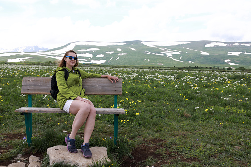 Woman sitting on bench on Lago-Naki plateau, Adygea