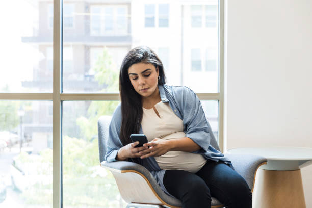 istock Expectant mother uses phone while waiting to see doctor 1426642818
