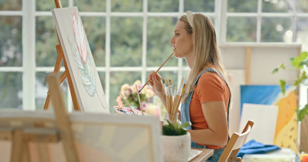 istock Thinking painter, painting art and creative learning at school, doubt about idea and confused about flower on canvas. Designer, artist or creativity student in workshop or studio for portrait artwork 1426645856