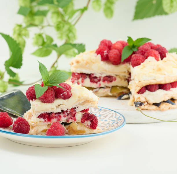 istock Round meringue pie with fresh raspberries on a white background, Pavlova dessert 1426646958