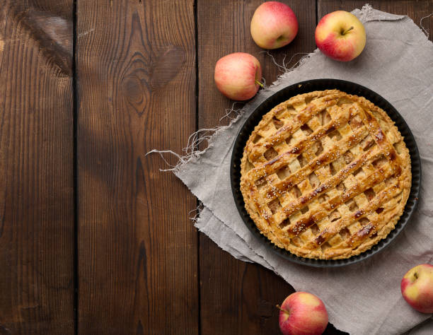 istock Round baked apple pie on a brown wooden table, top view 1426649366