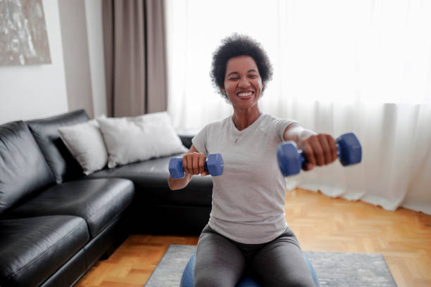 istock Mature attractive sportswoman doing exercises with weights at home 1426651235
