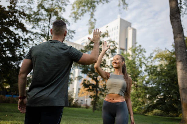 istock Two athletic people greeting each other with high five gesture during jogging workout 1426652305