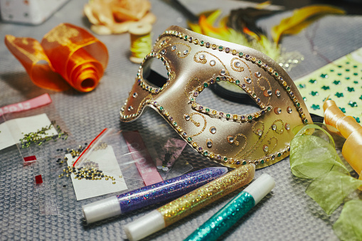 Carnival mask in the process of decoration and materials for its decoration. DIY masquerade mask for Mardi Gras, Fat Tuesday.