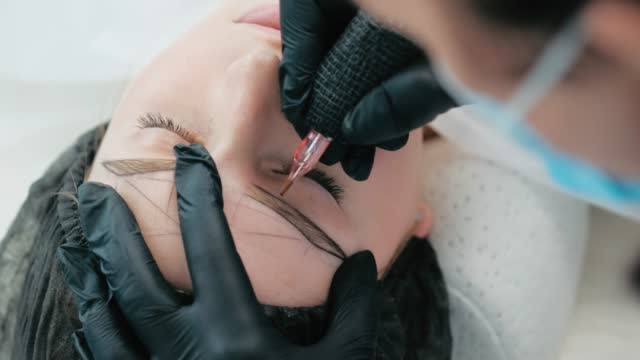 Cosmetologist making eyebrow permanent makeup