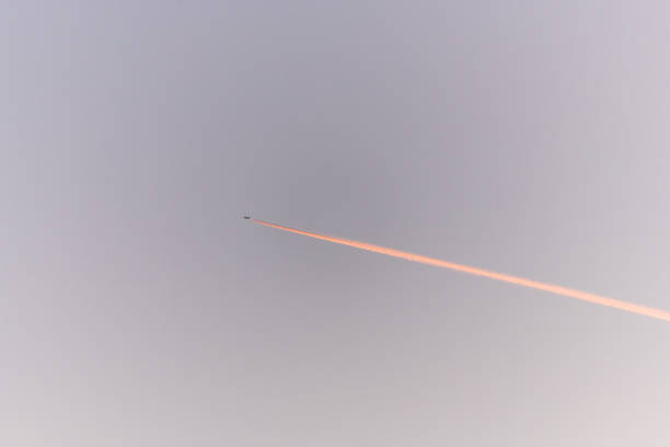 Airliners in flight in a cloudy pink and orange sky in late summer. France.