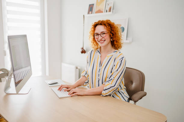 istock Portrait of redhead woman using computer at office 1426660773