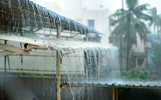 Rain on a Tin Roof. Rain Falling from the Roof. Rainy day nature background. Selective Focus on Foreground