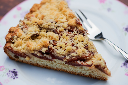 Plum crumble cake on a plate close up