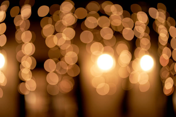 istock Abstract glowing bokeh lights highlighted on a black background. Festive golden glowing background with yellow lights. Overlay bokeh for your design. 1426663243