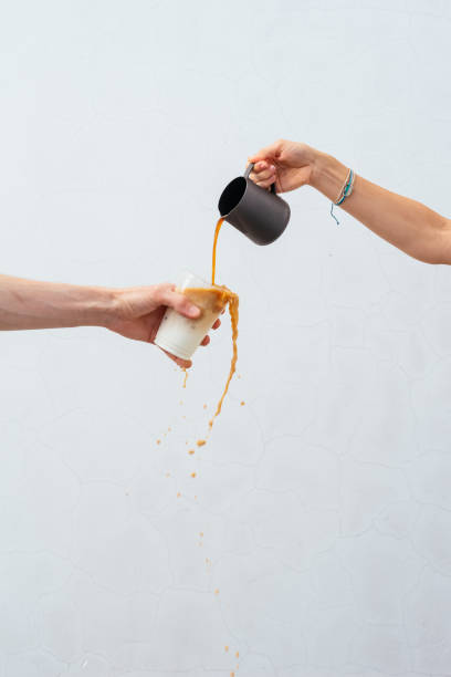 istock a woman's hand pours coffee into a glass 1426666892