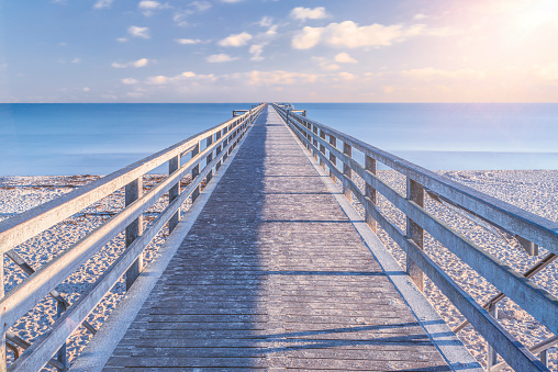 Path to the horizon, A pier leads out onto the open, calm sea to the horizon.