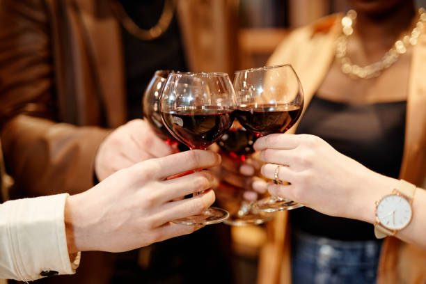 istock Hands of several young intercultural friends clinking with red wine 1426672497