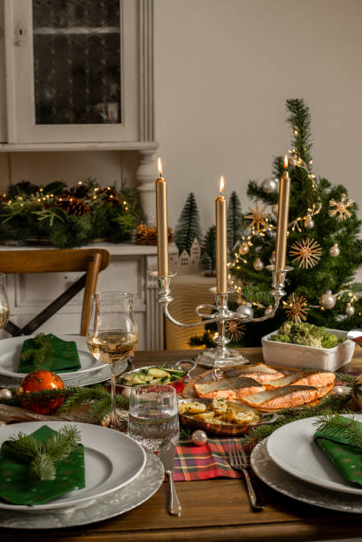 istock Christmas fish dinner with salmon fillets and Mediterranean vegetables in festive rustic kitchen home 1426673112