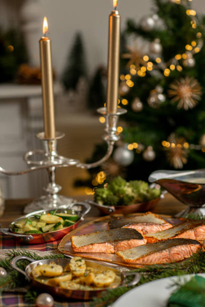 istock Christmas fish dinner with salmon fillets and Mediterranean vegetables in festive rustic kitchen home 1426673850