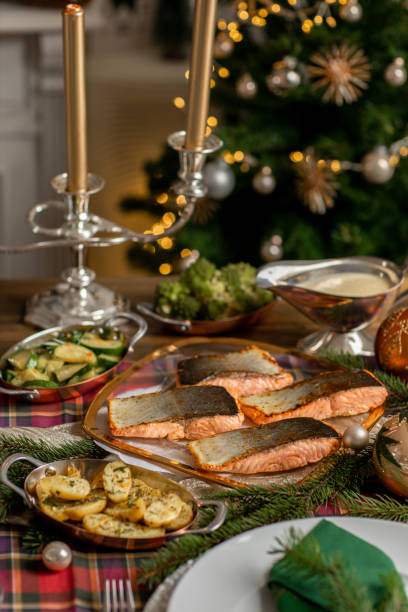 istock Christmas fish dinner with salmon fillets and Mediterranean vegetables in festive rustic kitchen home 1426674003