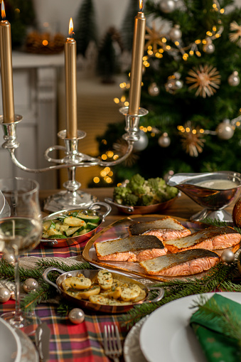 Christmas festive fish dinner with salmon fillets and Mediterranean vegetables in rustic kitchen home