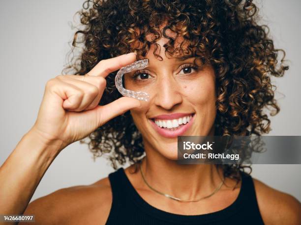 Smiling Woman Holding An Invisible Teeth Aligner Stock Photo - Download Image Now - Dental Aligner, Healthy Lifestyle, Teeth