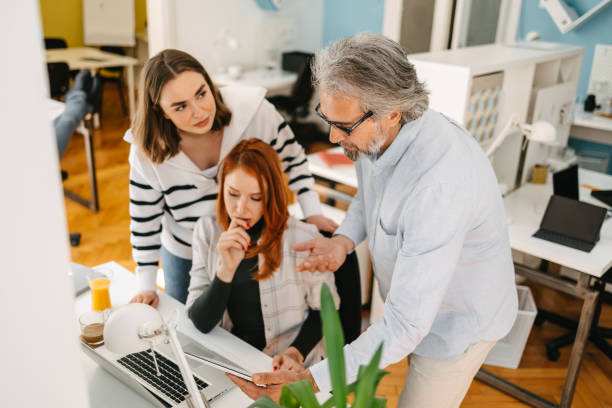 Team leader delegating tasks to his team A high-angle view of a grey-haired team leader delegating tasks to his team. delegating stock pictures, royalty-free photos & images