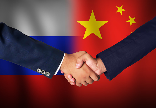 Russia and China Deal concept background with waving flag and handshake. Contract signing between Russia and china