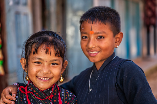 Nepali children wearing traditional Newari clothes going to the festival in an ancient town of Bhaktapur. Bhaktapur is an ancient town in the Kathmandu Valley and is listed as a World Heritage Site by UNESCO for its rich culture, temples, and wood, metal and stone artwork.