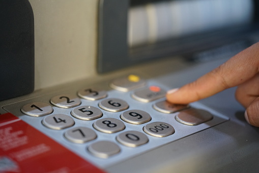Female hand using an ATM bank
