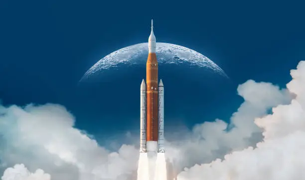 Photo of SLS space rocket in sky with clouds. Mission to Moon. Spaceship launch from Earth. Orion spacecraft. Artemis space program to research solar system. Elements of this image furnished by NASA
