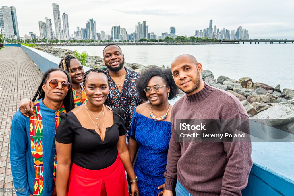 Portrait of Cheerful, Smiling, Fashionable Afro-Descendant Black Tourists Standing Together at Plaza V Centenario with a Skyline Evening View of Panama City Group of Cheerful, Smiling, Fashionable Afro-Descendant Black Young Men and Women Standing Together as Friends at Plaza V Centenario with a Skyline Evening View of Panama City, Panama Panama Stock Photo