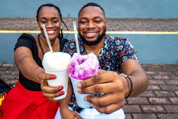 "Cheers!" Cute Portrait of an Afro-Descendant Friends Sitting Together and Holding "Raspao" Snow Cones at Plaza V Centenario in Panama City, Panama Cute Portrait of an Afro-Descendant Couple Sitting Together and Holding "Raspao" Snow Cones at Plaza V Centenario in Panama City, Panama afro latinx ethnicity stock pictures, royalty-free photos & images