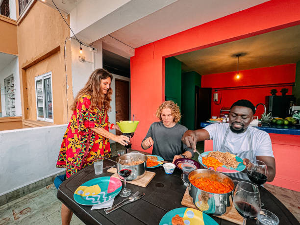 Multi-Racial Group Share a Delicious Dinner on a Balcony at a Bed & Breakfast in Panama City, Panama stock photo