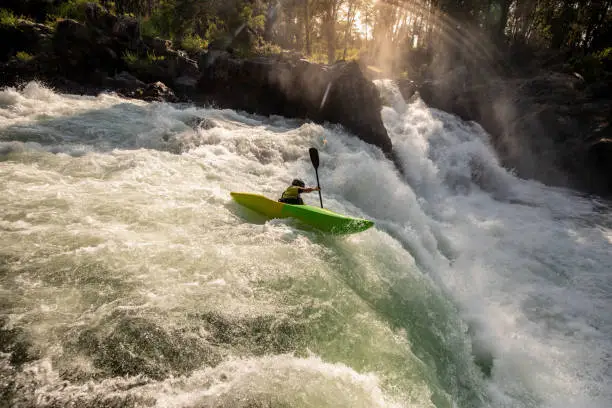 Photo of Kayaker Riding off of Waterfall