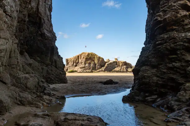 Looking through Rock Arch Towards Chapel Rock, at Perranporth Beach in Cornwall