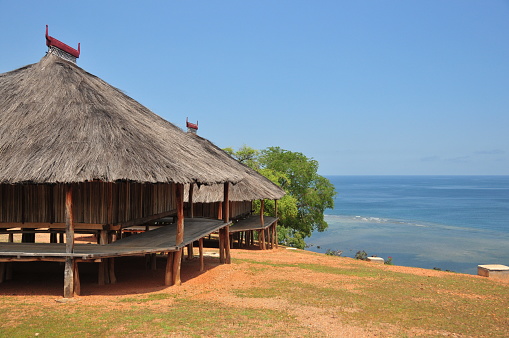 Tibar bay, Liquiçá municipality, East Timor / Timor Leste: traditional Timorese house with pyramid thatched roofs with horns and walls made of bamboo and areca palm. Uma fukun / uma lulik style.