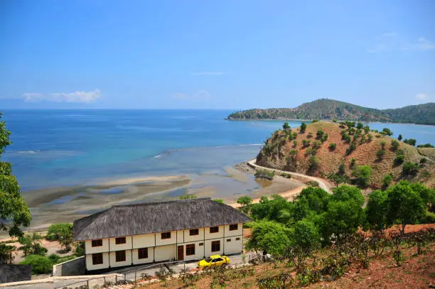 Photo of Traditional Timorese thatched roof building and the scenic coastline of Tibar bay, Liquiçá, East Timor