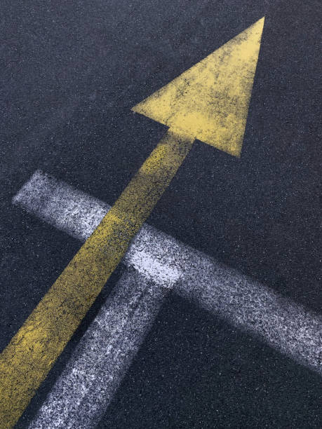 istock Close-up diagonal direction line painted in yellow on black asphalt 1426707910